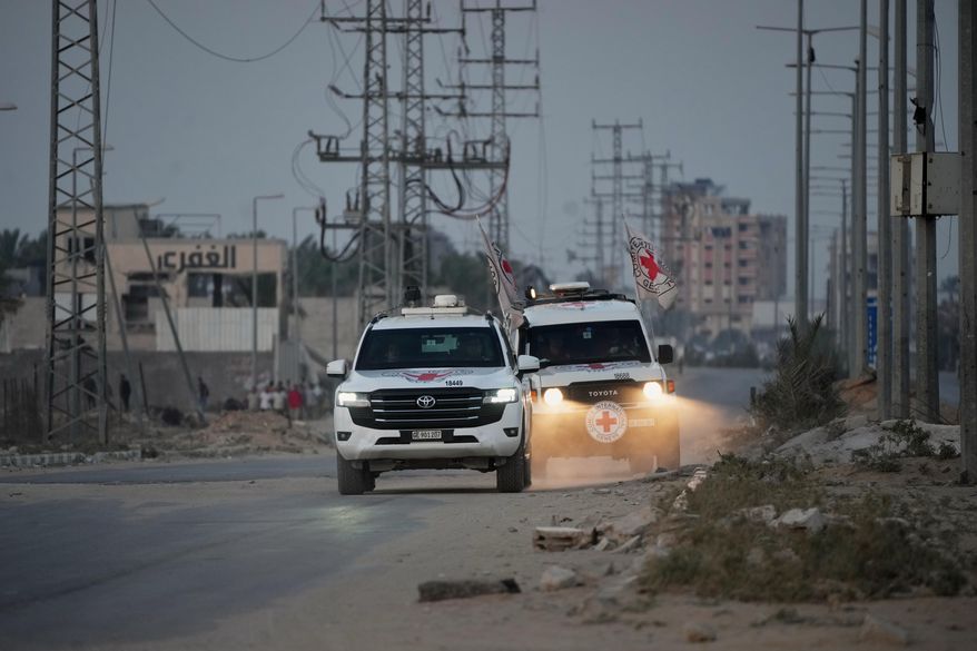 Red Cross vehicles carrying the bodies of two people believed to be deceased hostages handed over by Hamas make their way toward the Kissufim border crossing with Israel, to be transferred to Israeli authorities, in Deir al-Balah, central Gaza Strip, Thursday, Oct. 30, 2025. (AP Photo/Abdel Kareem Hana)