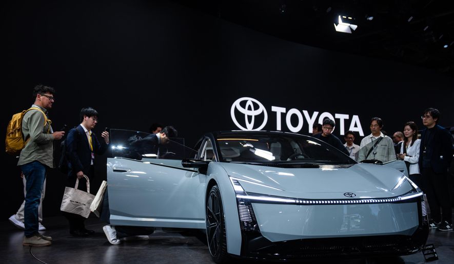 Members of the media and guests look at Toyota's Corolla concept during the press day of the Japan Mobility Show, in Tokyo, Thursday, Oct. 30, 2025. (AP Photo/Louise Delmotte)
