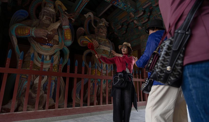 A guide briefs visitors at the Bulguksa Temple where preparations are underway ahead of events for attendees of the Asia-Pacific Economic Cooperation (APEC) summits in Gyeongju, South Korea, Thursday, Oct. 30, 2025. (AP Photo/Ng Han Guan)