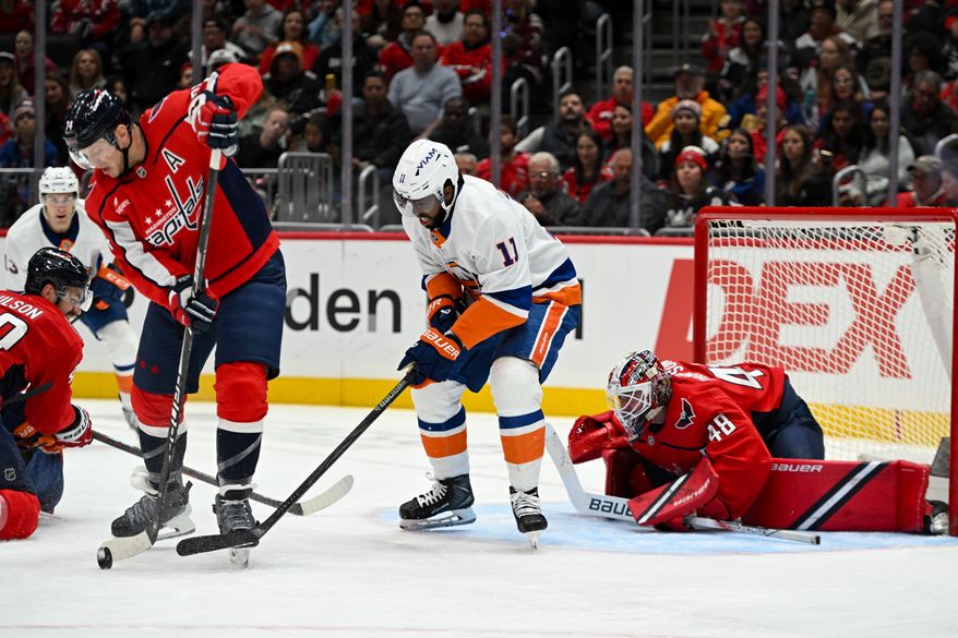 New York Islanders forward Anthony Duclair (11) fighting for control of the puck with Washington Capitals defenseman John Carlson (74) in front of goalie Logan Thompson (48) during the second period of an NHL game at Capital One Arena in Washington D.C., October 31, 2025. (Photo for the Washington Times)
