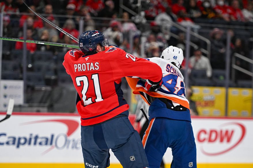 Washington Capitals center Alexei Protas (21) putting a hit on New York Islanders defenseman Matthew Schaefer (48) during the third period of an NHL game against the New York Islanders at Capital One Arena in Washington D.C., October 31, 2025. (Photo for the Washington Times)