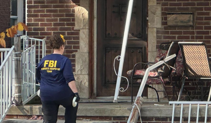 An FBI agent enters a home in a Dearborn, Mich., neighborhood on Friday, Oct. 31, 2025. (AP Photo/Mike Householder)