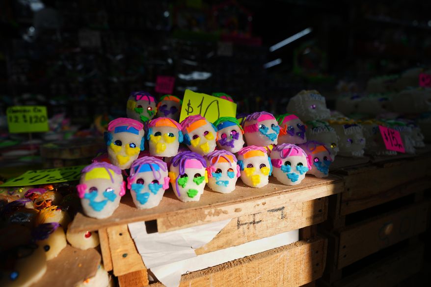 Sugar skulls known as “calaveritas” or little skulls, traditionally added to Day of the Dead altars honoring deceased loved ones, are displayed for sale at the Dulces de Ampudia market in Mexico City, Thursday, Oct. 30, 2025. (AP Photo/Claudia Rosel)