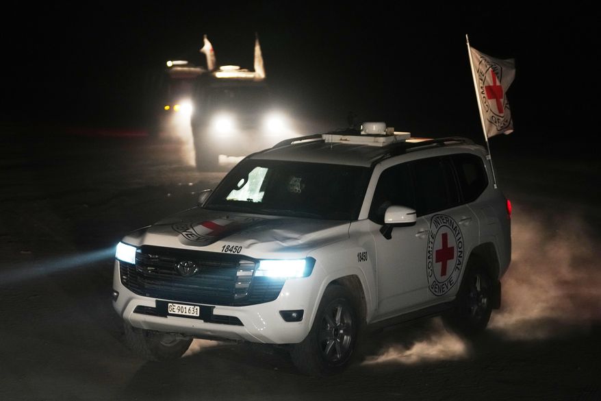 Red Cross vehicles carrying the bodies of three people believed to be deceased hostages handed over by Hamas make their way toward the border crossing with Israel, to be transferred to Israeli authorities, in Deir al-Balah, central Gaza Strip, Sunday, Nov. 2, 2025. (AP Photo/Jehad Alshrafi)