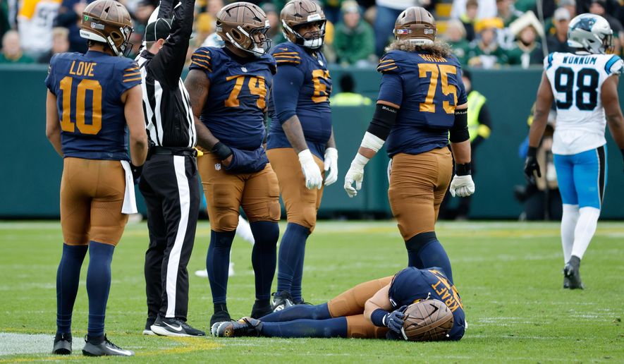 Green Bay Packers tight end Tucker Kraft, bottom, reacts after an injury during the second half of an NFL football game against the Carolina Panthers, Sunday, Nov. 2, 2025, in Green Bay, Wis. (AP Photo/Mike Roemer)