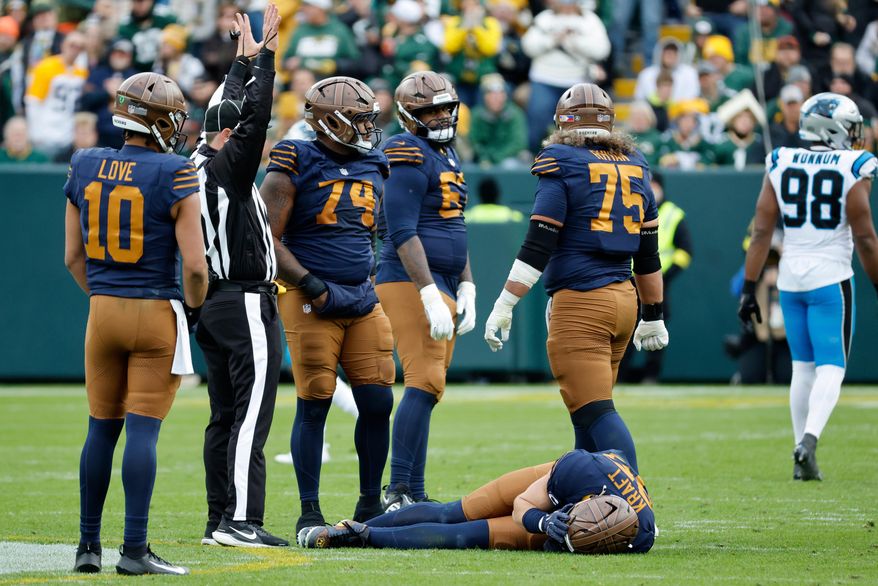 Green Bay Packers tight end Tucker Kraft, bottom, reacts after an injury during the second half of an NFL football game against the Carolina Panthers, Sunday, Nov. 2, 2025, in Green Bay, Wis. (AP Photo/Mike Roemer)
