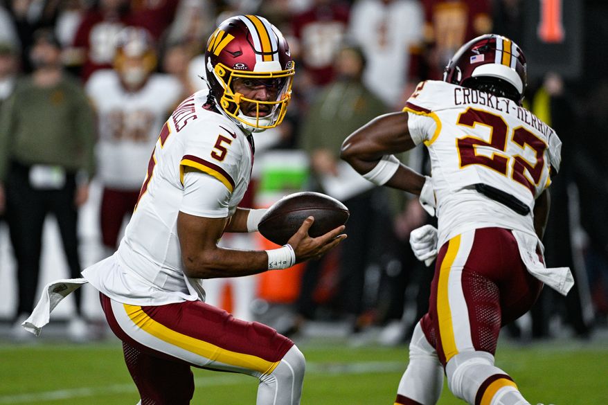 Washington Commanders quarterback Jayden Daniels (5) rolls out of the pocket after faking a handoff to running back Jacory Crosby-Merritt (22) against the Seattle Seahawks at Northwest Stadium in Landover, Maryland, November 2, 2025. (Photo by Brian Murphy for the Washington Times)