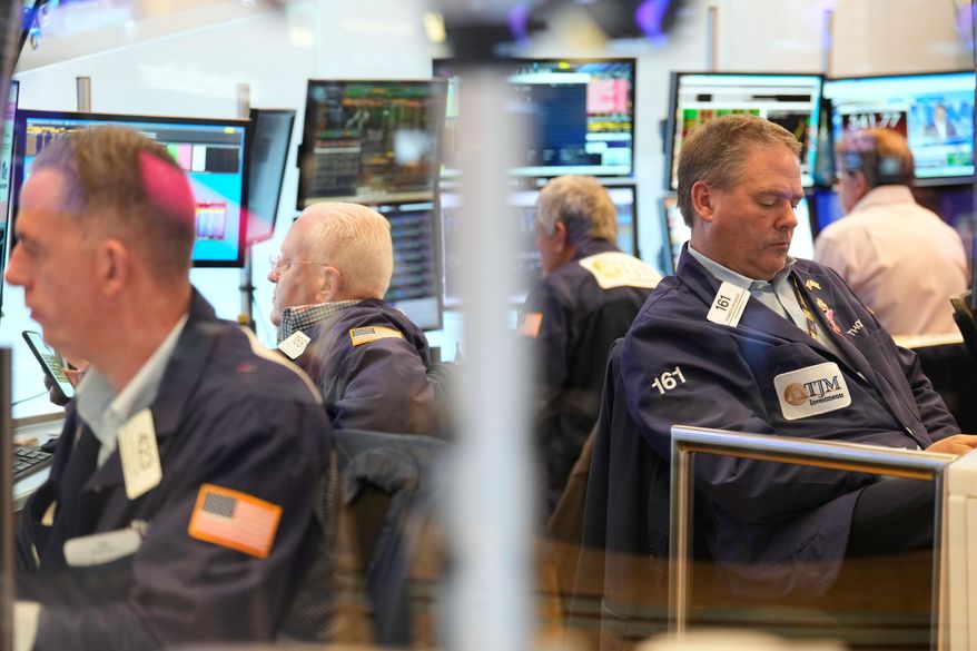 Traders, including Thomas McCauley, second from right, work on the floor at the New York Stock Exchange in New York, Wednesday, Oct. 29, 2025. (AP Photo/Seth Wenig)