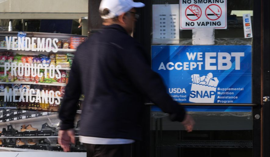 A customer walks into a bakery as a SNAP EBT information sign is displayed at the front door in Chicago, Sunday, Nov. 2, 2025. (AP Photo/Nam Y. Huh)