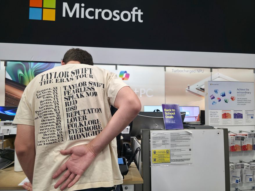 FILE - Middle school teacher Jeremy Hook shops for the latests Microsoft's Surface Laptop Copilot+ PC's at Best Buy Atwater Village store in Glendale, Calif., Tuesday, July 29, 2025. (AP Photo/Damian Dovarganes, File)