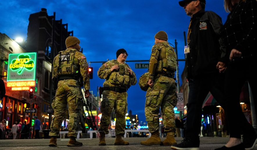 Members of the National Guard stand watch at the intersection of B.B. King Blvd. and Beale Street, Friday, Oct. 24, 2025, in Memphis, Tenn. (AP Photo/George Walker IV)