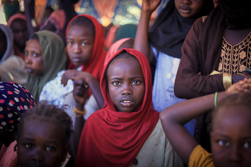 This photo released by The Norwegian Refugee Council (NRC), shows displaced women and children from el-Fasher at a camp where they sought refuge from fighting between government forces and the RSF, in Tawila, Darfur region, Sudan, Monday, Nov. 3, 2025. (Marwan Mohammed/NRC via AP)