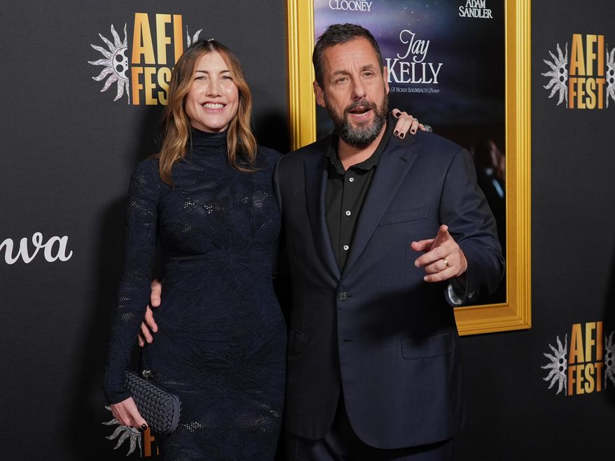 Adam Sandler, right, a cast member in "Jay Kelly," arrives with his wife Jackie Sandler at the AFI Fest premiere of the film on Thursday, Oct. 23, 2025, at TCL Chinese Theatre in Los Angeles. (AP Photo/Chris Pizzello)