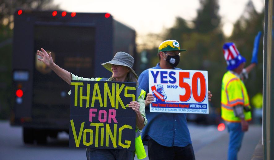 From left: Jennifer York, Zac Britton, and George Reed encourage passing motorists to vote Yes on Prop 50 along Bicentennial Way in Santa Rosa, Calif., on Monday Nov. 3, 2025. (Alvin A.H. Jornada/San Francisco Chronicle via AP)