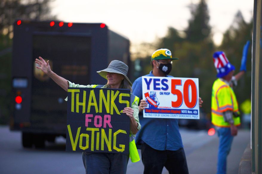 From left: Jennifer York, Zac Britton, and George Reed encourage passing motorists to vote Yes on Prop 50 along Bicentennial Way in Santa Rosa, Calif., on Monday Nov. 3, 2025. (Alvin A.H. Jornada/San Francisco Chronicle via AP)