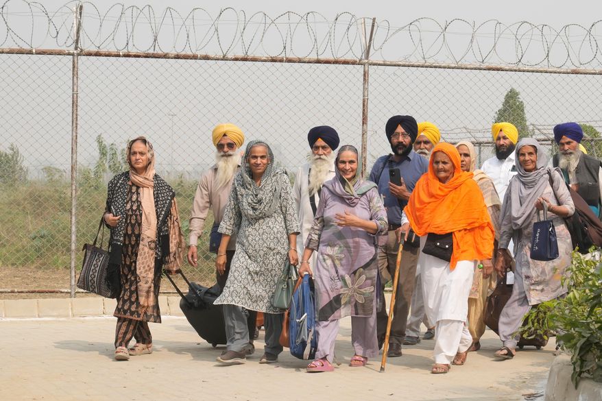 Indian Sikh pilgrims enter Pakistan through the Wagah border crossing point, to participate in celebrations marking the birth anniversary of Guru Nanak, at Gurdwara Janam Asthan Nankana Sahib, near Lahore, Pakistan, Tuesday, Nov. 4, 2025. (AP Photo/K.M. Chaudary)