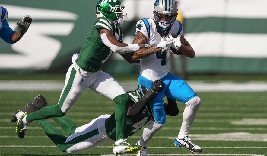 Carolina Panthers wide receiver Tetairoa McMillan (4) is tackled by New York Jets cornerback Sauce Gardner (1) and linebacker Jamien Sherwood (44) during the second quarter of an NFL football game, Sunday, Oct. 19, 2025, in East Rutherford, N.J. (AP Photo/Seth Wenig)