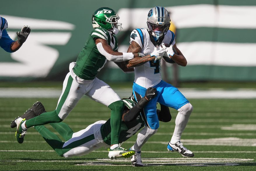 Carolina Panthers wide receiver Tetairoa McMillan (4) is tackled by New York Jets cornerback Sauce Gardner (1) and linebacker Jamien Sherwood (44) during the second quarter of an NFL football game, Sunday, Oct. 19, 2025, in East Rutherford, N.J. (AP Photo/Seth Wenig)