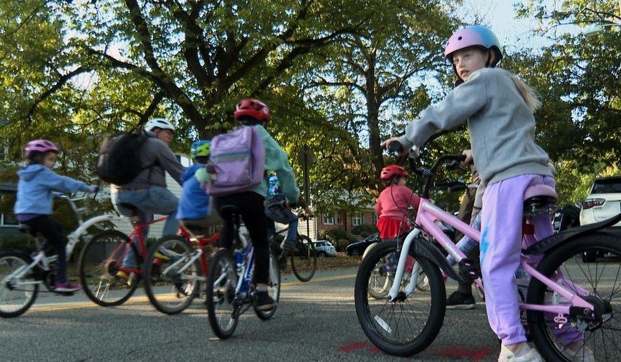 In an image taken from video, children ride their bicycles to school during a parent-led bike ride titled "Bike Bus" Oct. 3, 2025, in Montclair, N.J. (AP Photo/Tassanee Vejpongsa)