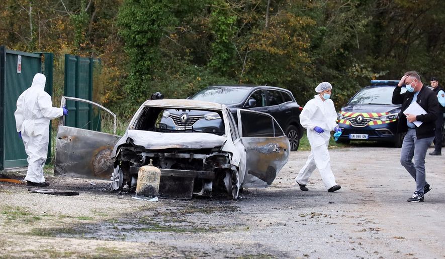 Investigators inspect the burned car after a motorist deliberately rammed pedestrians and cyclists across two neighbouring towns on the Ile d'Oleron, off the Atlantic coast, injuring people before being detained by gendarmes, Wednesday, Nov. 5, 2025. (AP Photo/Yohan Bonnet)