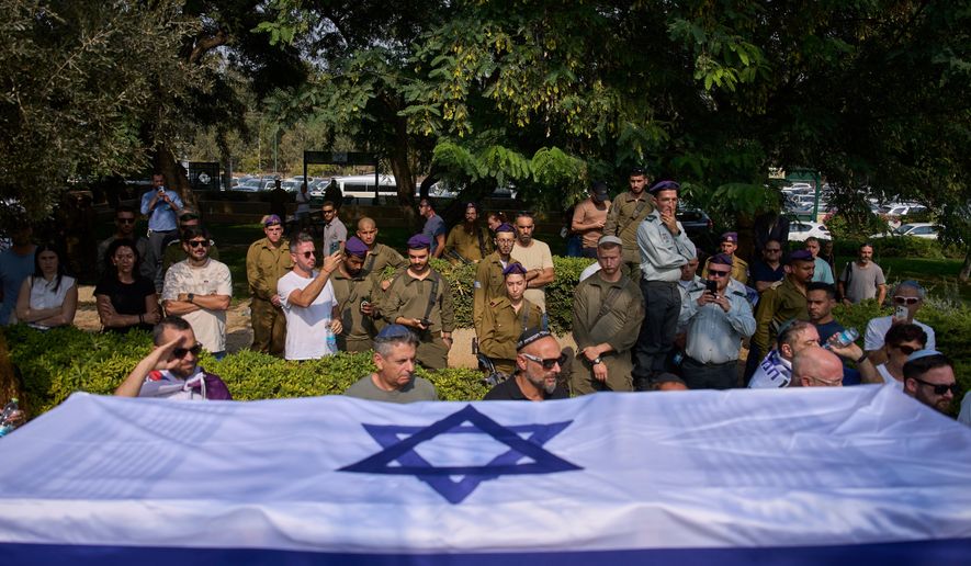 Israeli soldiers carry the flag-draped coffin of slain hostage Col. Asaf Hamami, who was abducted by Hamas militants on Oct. 7, 2023, during his funeral at Kiryat Shaul military cemetery, in Tel Aviv, Israel, Tuesday, Nov. 4, 2025. (AP Photo/Ohad Zwigenberg)