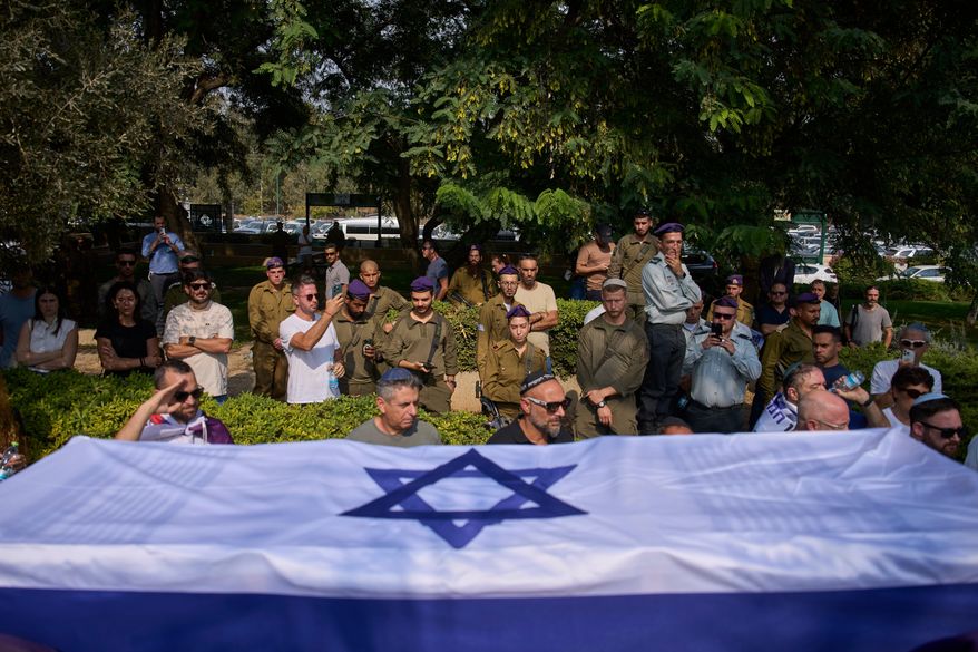 Israeli soldiers carry the flag-draped coffin of slain hostage Col. Asaf Hamami, who was abducted by Hamas militants on Oct. 7, 2023, during his funeral at Kiryat Shaul military cemetery, in Tel Aviv, Israel, Tuesday, Nov. 4, 2025. (AP Photo/Ohad Zwigenberg)