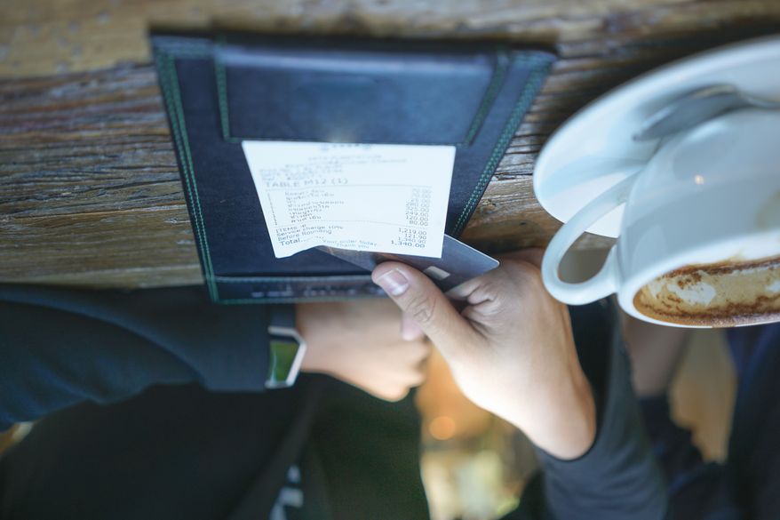 A businessman is paying his bill by credit card at a restaurant. File photo credit: Totsapon Phattaratharnwan via Shutterstock.