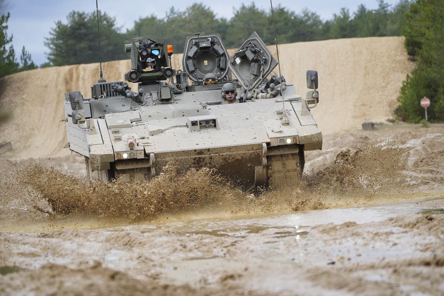 An Ajax Ares tank, an armored personnel carrier, is driven on the training range at Bovington Camp, a British Army military base, during a visit by Defence Secretary Ben Wallace, who is viewing Ukrainian soldiers training on Challenger 2 tanks, in Dorset, England, on Wednesday, Feb. 22, 2023. (Ben Birchall/Pool via AP) **FILE**