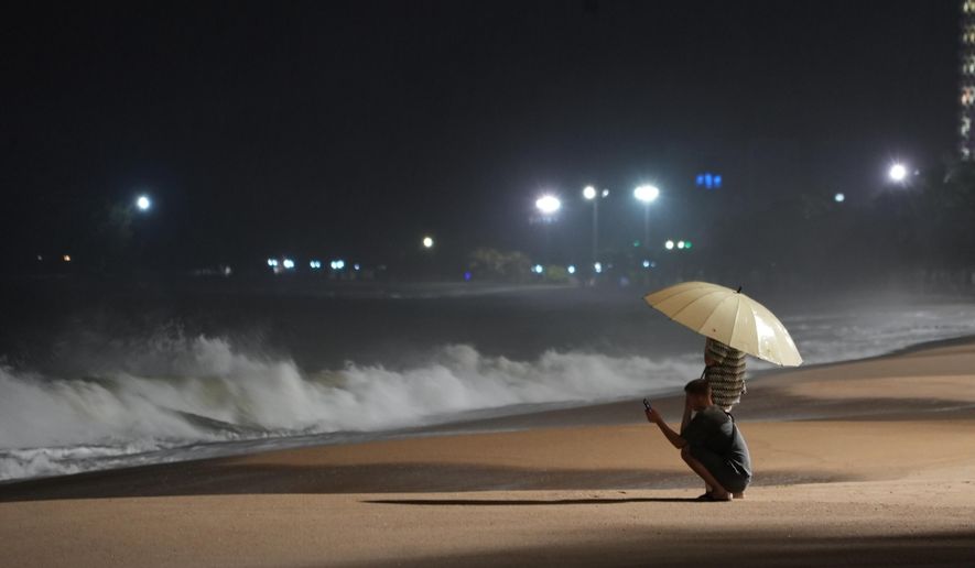 People watch rough waves caused by Typhoon Kalmaegi in Khanh Hoa, Vietnam, Thursday, Nov. 6, 2025. (AP Photo/Hau Dinh)