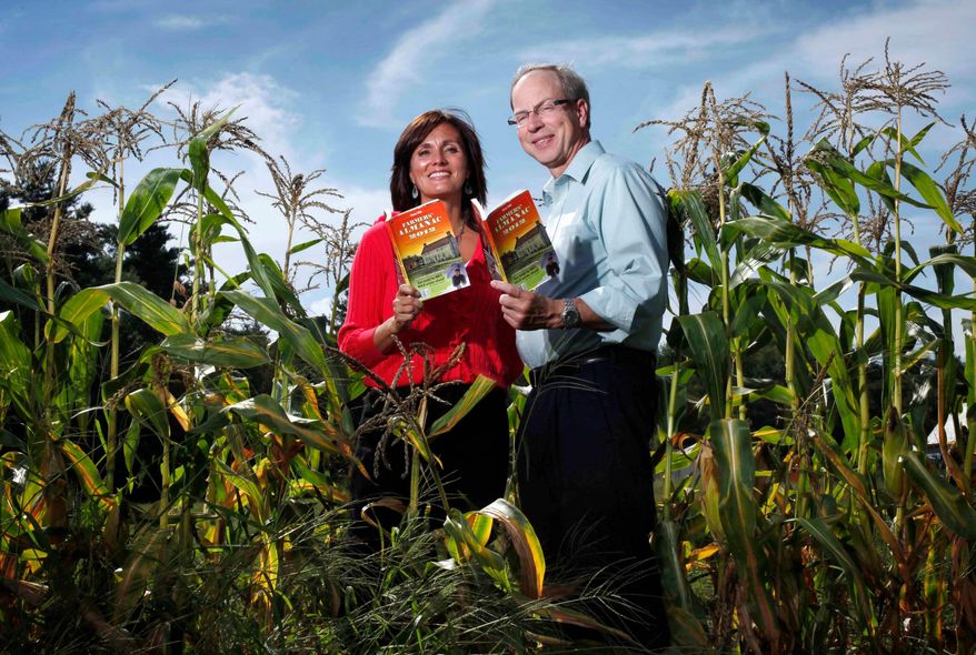 Farmers' Almanac editor Sondra Duncan and publisher Peter Geiger pose in a corn field with the 2012 edition of the almanac, Aug. 24, 2011, in Auburn, Maine. (AP Photo/Robert F. Bukaty, File)