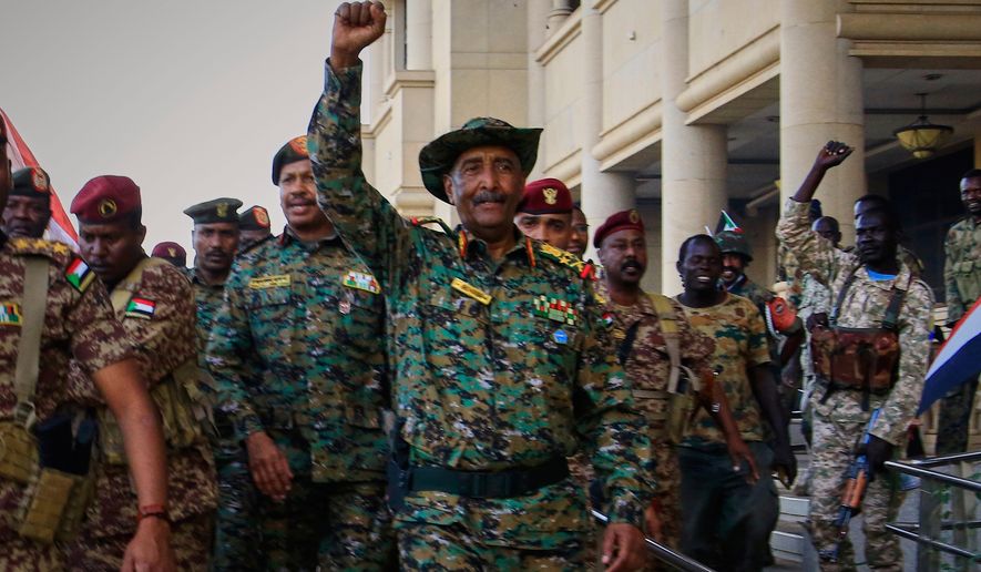 FILE - Sudan's military chief Gen. Abdel-Fattah Burhan, center, is greeted by troops as he arrives at the Republican Palace, recently recaptured from the Rapid Support Forces (RSF) paramilitary group, in Khartoum, Sudan, March 26, 2025. (AP Photo/File)