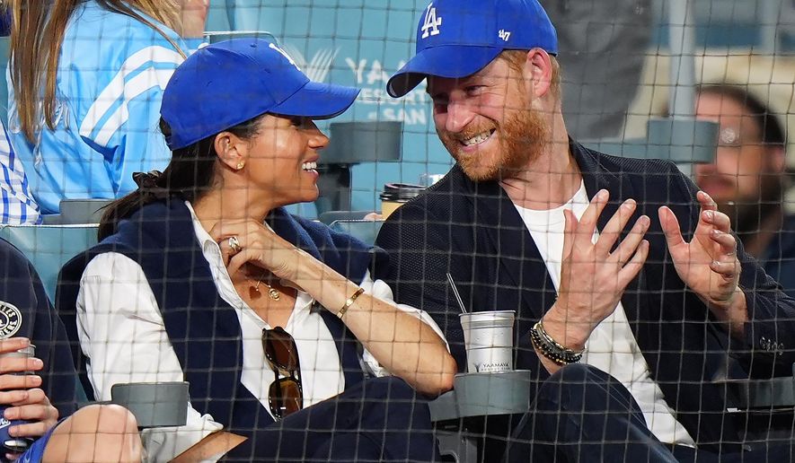 Prince Harry, right, and Meghan Markle, Duke and Duchess of Sussex, sit during the eighth inning in Game 4 of baseball's World Series between the Los Angeles Dodgers and the Toronto Blue Jays in Los Angeles, Tuesday, Oct. 28, 2025. (Frank Gunn/The Canadian Press via AP)