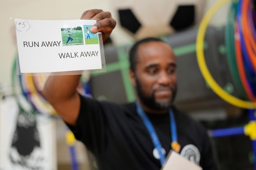 Health and physical education teacher Ronald Anderson holds instructions for students when they encounter a firearm during a gun safety lesson at Berclari Elementary School, Monday, Oct. 27, 2025, in Memphis, Tenn. (AP Photo/George Walker IV)