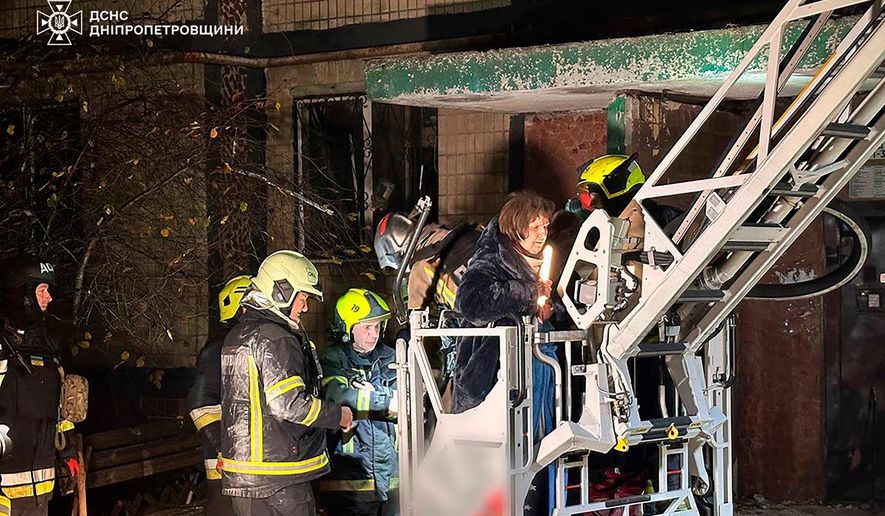In this photo provided by the Ukrainian Emergency Service, firefighters evacuate a resident following a Russian rocket attack that hit a multi-storey apartment building in Dnipro, Ukraine, Saturday, Nov. 8, 2025. (Ukrainian Emergency Service via AP)