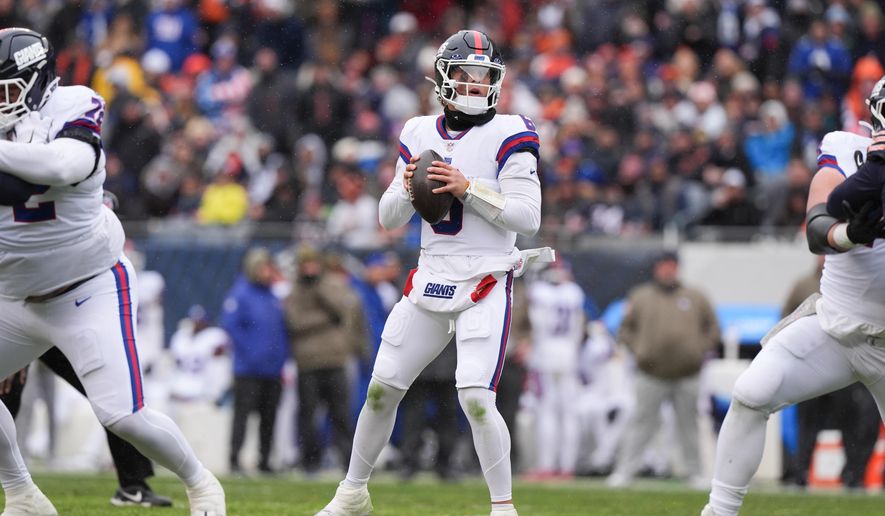 New York Giants quarterback Jaxson Dart, center, looks to throw during the first half of an NFL football game against the Chicago Bears, Sunday, Nov. 9, 2025, in Chicago. (AP Photo/Nam Y. Huh)