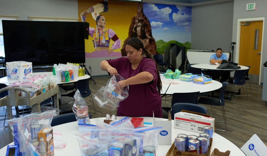 Carla Teran helps prepare bagged meals for a food bank for students at Nueta Hidatsa Sahnish College, Thursday, Oct. 30, 2025, in New Town, N.D. (AP Photo/John Locher)