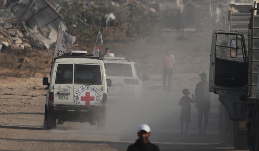Red Cross convoy carrying what Hamas claims is the remains of an Israeli soldier who was killed in Gaza in 2014 and whose body has been held in Gaza since. makes its way toward the border crossing with Israel, to be transferred to Israeli authorities, in Deir al-Balah, Gaza Strip, Sunday, Nov. 9, 2025. (AP Photo/Jehad Alshrafi)