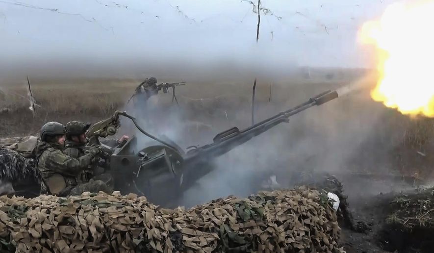 In this image made from video provided by Russian Defense Ministry Press Service on Friday, Nov. 7, 2025, Russian army soldiers fire to shoot a Ukrainian drone on an undisclosed location in Ukraine. (Russian Defense Ministry Press Service via AP)