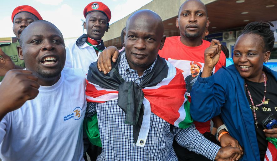 Kenyan human rights activist Nicholas Oyoo, centre, arrives at Jomo Kenyatta International Airport (JKIA) in Nairobi, Kenya, Saturday, Nov. 9, 2025. (AP Photo/Andrew Kasuku)