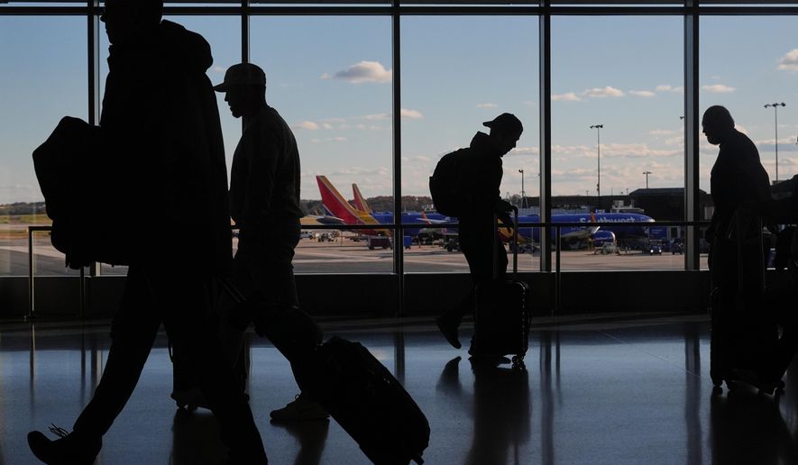 Southwest Airlines planes sit at gates as travelers walk through Baltimore/Washington International Thurgood Marshall Airport in Baltimore, Monday, Nov. 10, 2025. (AP Photo/Stephanie Scarbrough)