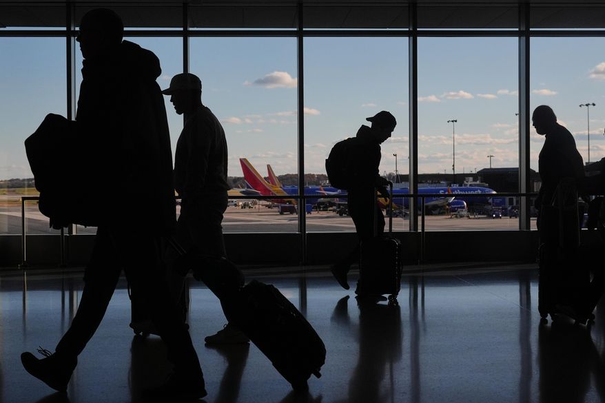Southwest Airlines planes sit at gates as travelers walk through Baltimore/Washington International Thurgood Marshall Airport in Baltimore, Monday, Nov. 10, 2025. (AP Photo/Stephanie Scarbrough)