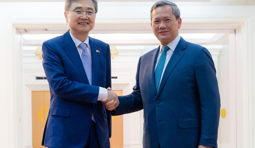 In this photo released by Agence Kampuchea Press (AKP), Cambodian Prime Minister Hun Manet, right, shakes hands with South Korean Foreign Minister Cho Hyun, left, prior to a meeting in Phnom Penh, Cambodia, Monday, Nov. 10, 2025. (AKP via AP)