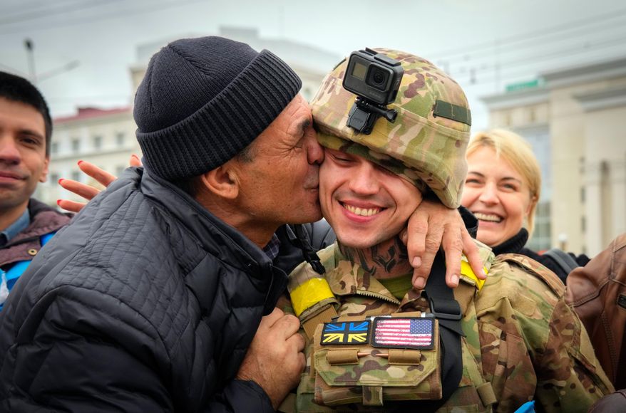 FILE - In this photo taken Sunday, Nov. 13, 2022, a Kherson resident kisses a Ukrainian soldier as Ukrainian army liberated the city from the Russian troops in Kherson, Ukraine, Nov. 13, 2022. (AP Photo/Efrem Lukatsky, file)