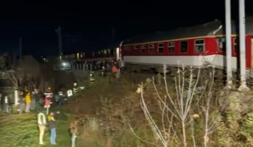 In this image made from video provided by Slovakia's Fire Service, passangers are guided by emergency services after a train crash in Pezinok, Slovakia, Sunday, Nov. 9, 2025. (Slovakia's Fire Service via AP)