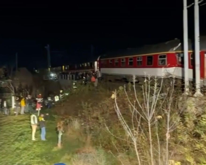 In this image made from video provided by Slovakia's Fire Service, passangers are guided by emergency services after a train crash in Pezinok, Slovakia, Sunday, Nov. 9, 2025. (Slovakia's Fire Service via AP)