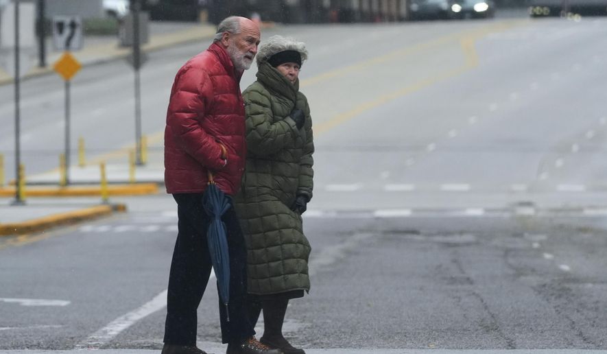 Pedestrians cross a street during a cold day in Chicago, Sunday, Nov. 9, 2025. (AP Photo/Nam Y. Huh)