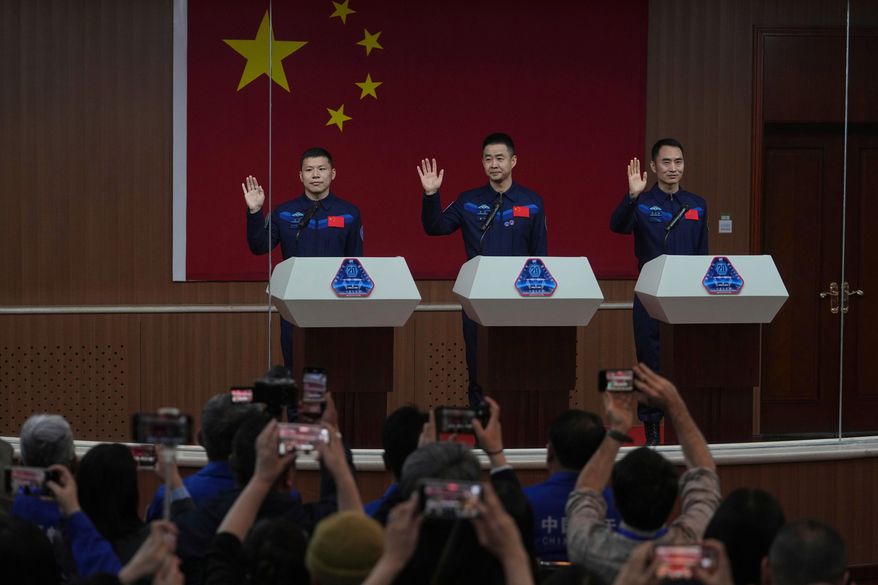 Journalists film Chinese astronauts for the upcoming Shenzhou 20 mission, from left, Wang Jie, Capt. Chen Dong and Chen Zhongrui wave at the Jiuquan Satellite Launch Center in northwest China, Wednesday, April 23, 2025. (AP Photo/Andy Wong, File)