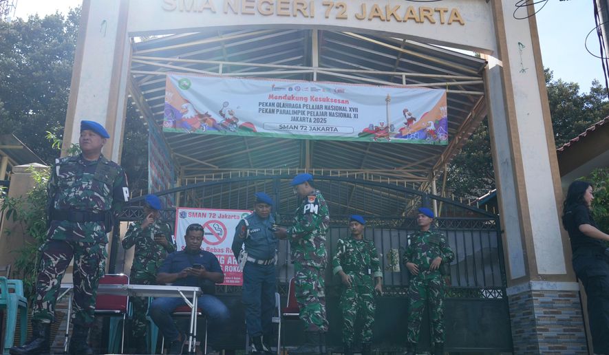 Military personnel stand guard at the gate of a school after explosions in Jakarta, Indonesia, Sunday, Nov. 9, 2025. (AP Photo/Achmad Ibrahim)