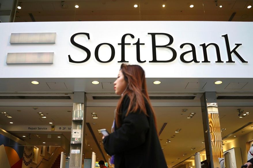 A woman walks in front of SoftBank store in Ginza shopping district in Tokyo, Jan. 20, 2020. (AP Photo/Eugene Hoshiko, File)
