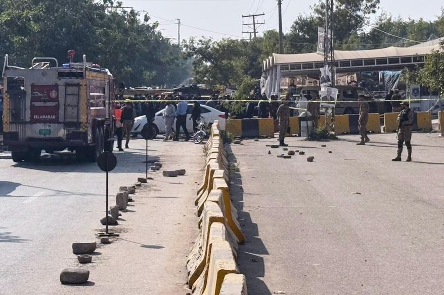 Pakistani security officials stand guard after a powerful car bomb exploded outside a district court in Islamabad, Pakistan, Tuesday, Nov. 11, 2025. (AP Photo/Mohammad Yousuf)